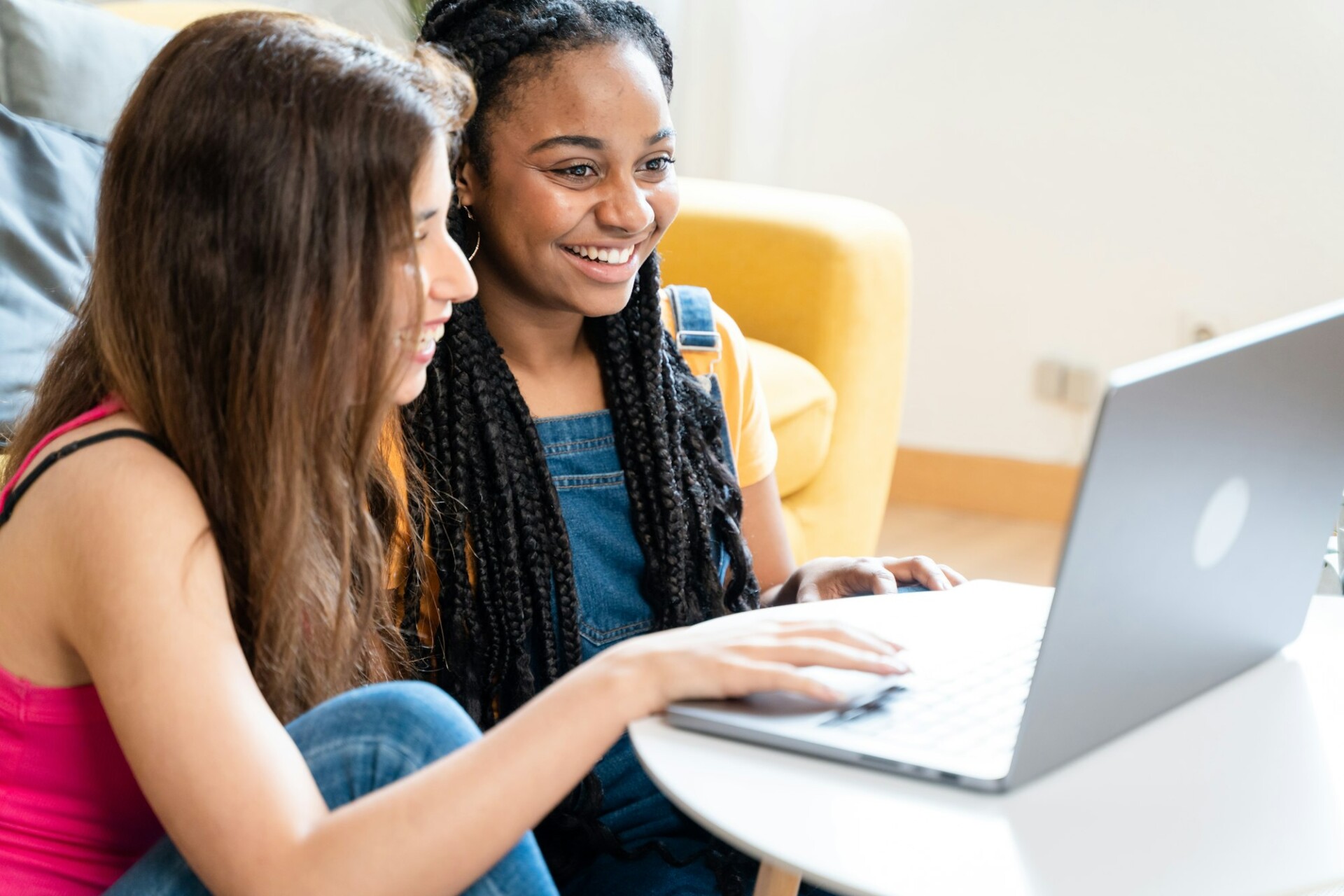 Female friends using laptop to browse fashion websites.